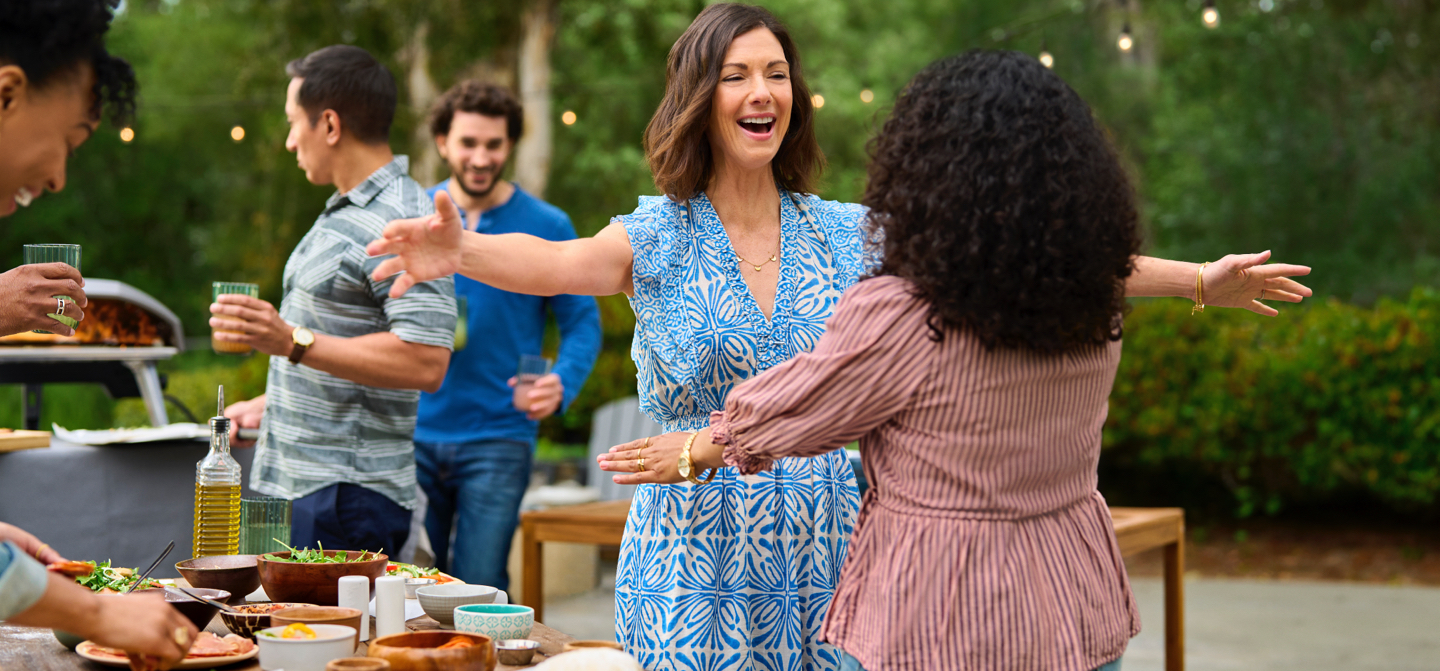 woman embracing a loved one at a pizza party